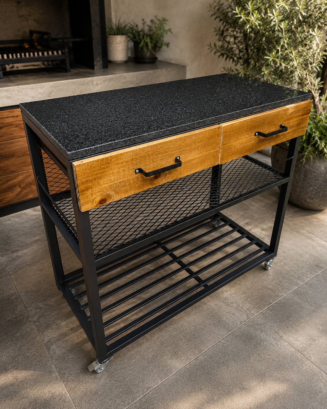 Mesa auxiliar artesanal con estructura de hierro y tapa superior de granito negro para quincho