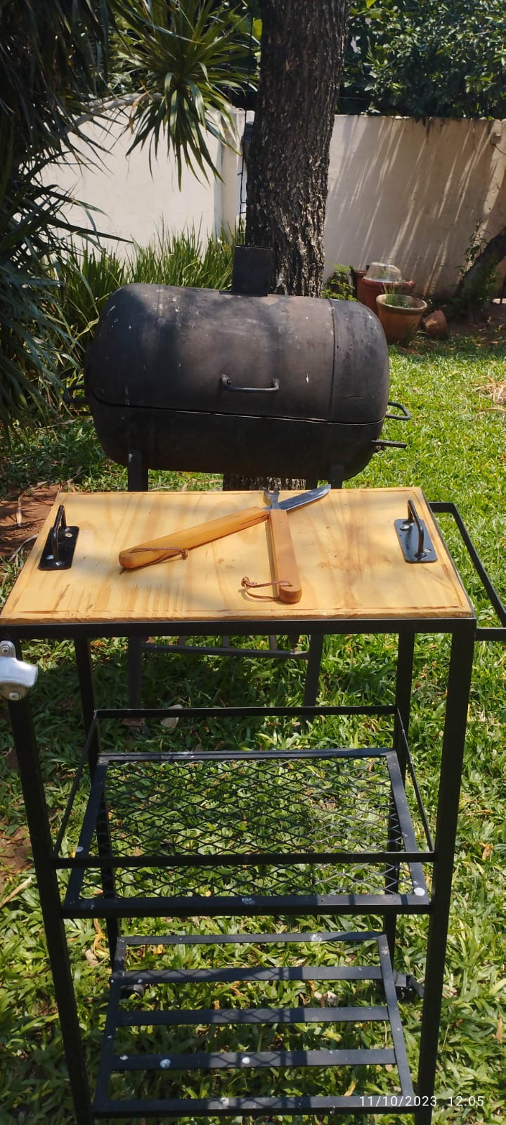 Mesa de apoyo para parrillero en uso frente a la parrilla